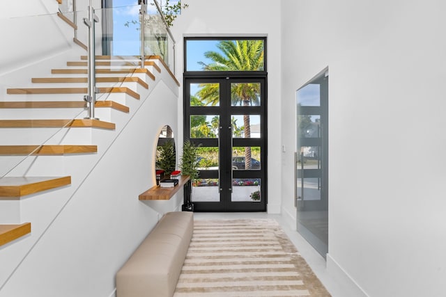 foyer entrance featuring french doors and a towering ceiling