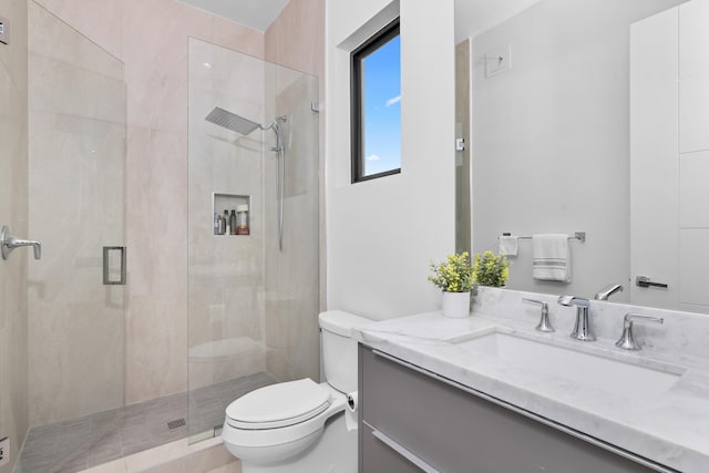 bathroom with walk in shower, vanity, and toilet