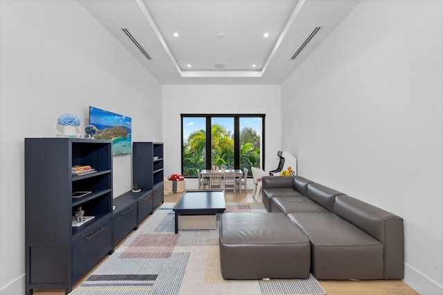 living room with a towering ceiling and a raised ceiling