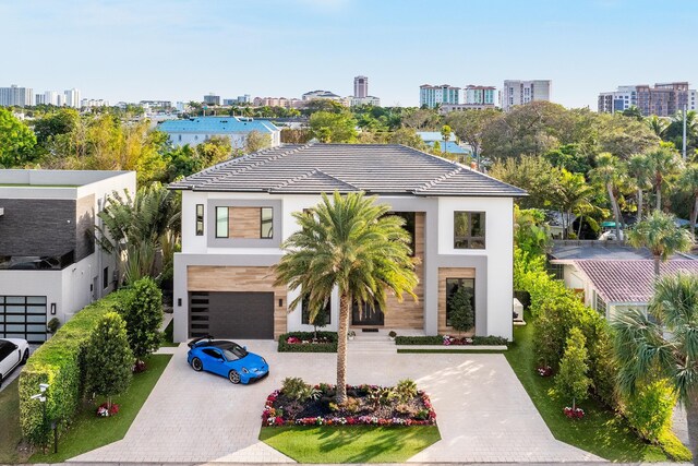 510 NE 4th Ln, Boca Raton, FL 33432 - modern home with stucco siding, decorative driveway, a city view, an attached garage, and a tiled roof