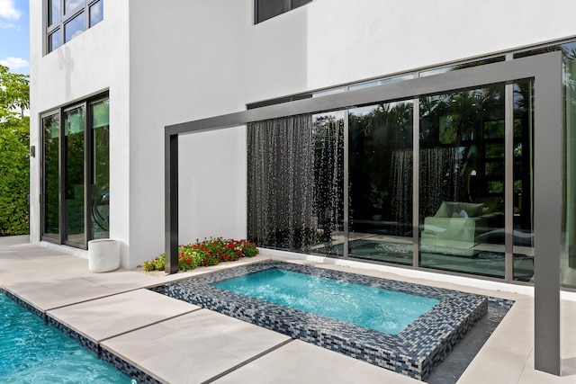 view of swimming pool featuring a patio and an in ground hot tub