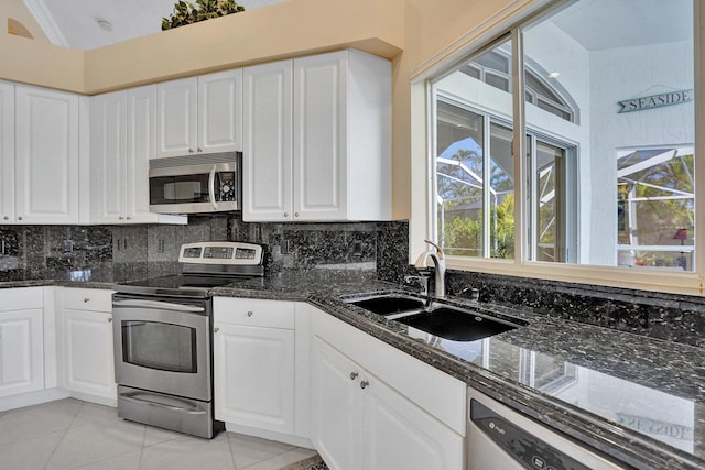 kitchen featuring sink, white cabinets, stainless steel appliances, and light tile patterned flooring