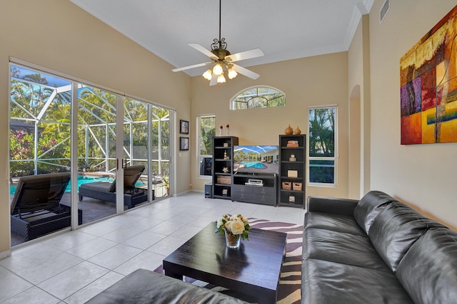 living room featuring ceiling fan, light tile patterned flooring, and a towering ceiling