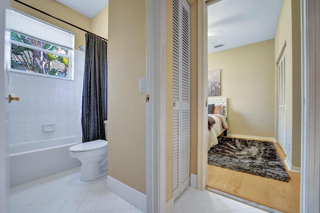 bathroom with toilet, tile patterned flooring, and shower / bath combo