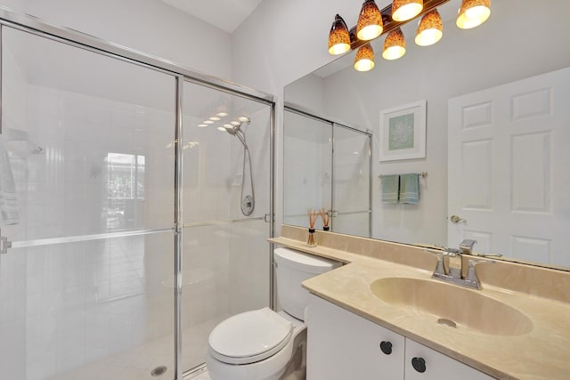 bathroom with toilet, a shower with shower door, and vanity