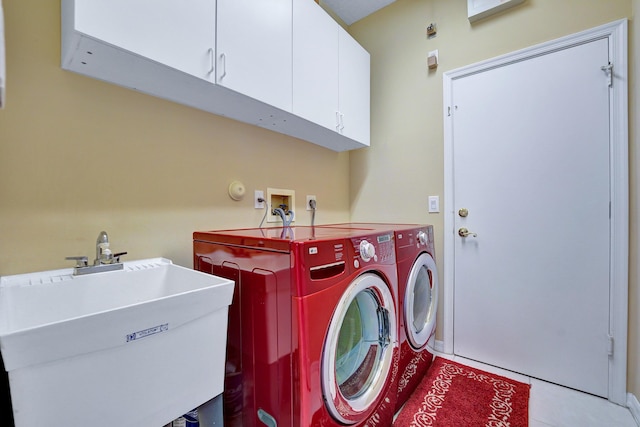 washroom with cabinets, sink, light tile patterned flooring, and washing machine and clothes dryer