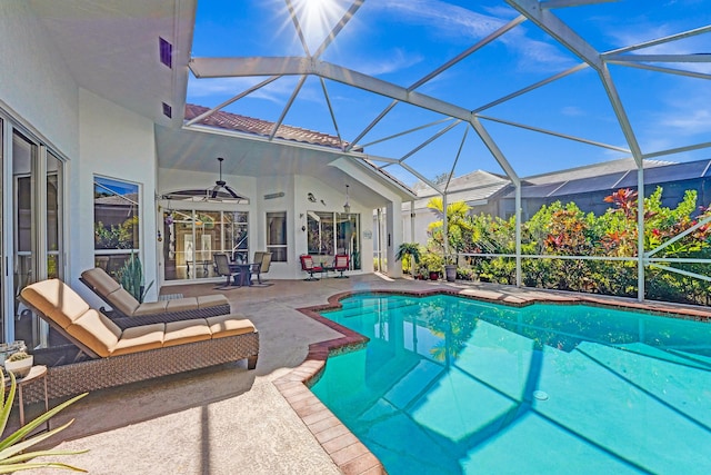 view of pool with a lanai, ceiling fan, an outdoor living space, and a patio