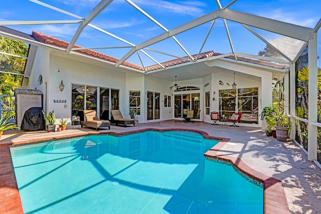 view of swimming pool featuring ceiling fan, a patio area, and glass enclosure