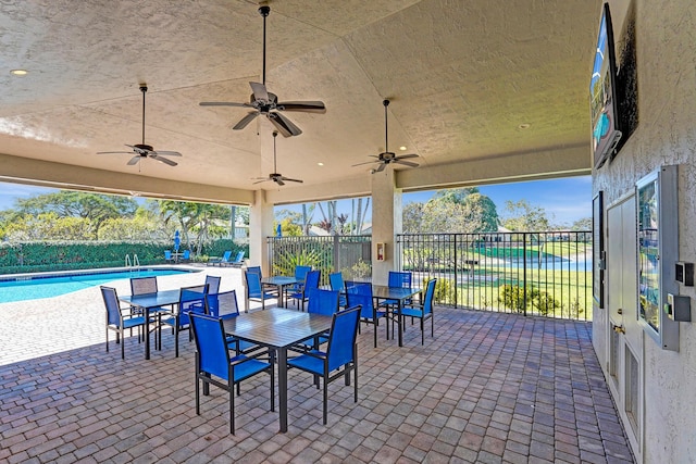 view of patio / terrace featuring a water view, ceiling fan, and a fenced in pool