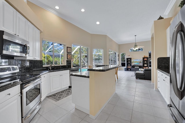 kitchen featuring light tile patterned floors, appliances with stainless steel finishes, decorative backsplash, white cabinets, and sink