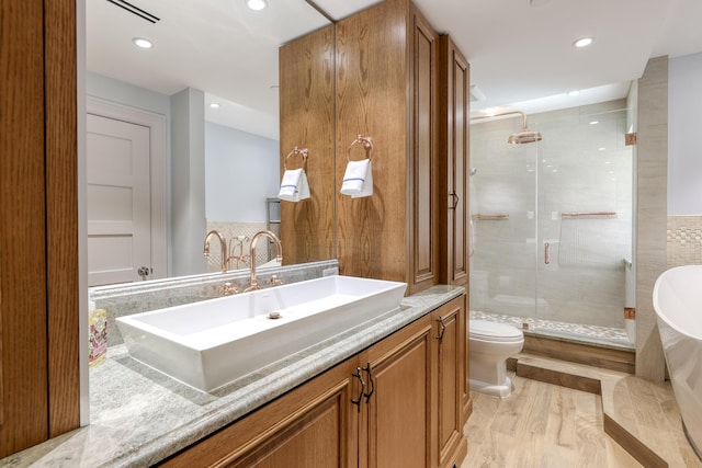 bathroom featuring vanity, wood-type flooring, an enclosed shower, and toilet