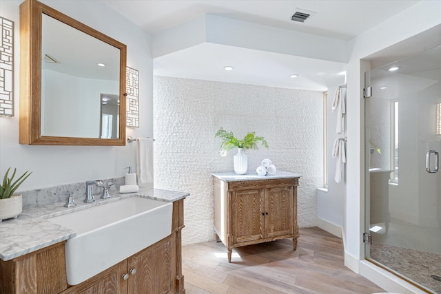 bathroom featuring vanity, wood-type flooring, and an enclosed shower