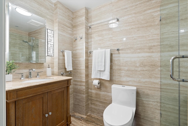 bathroom with walk in shower, vanity, toilet, and tile walls