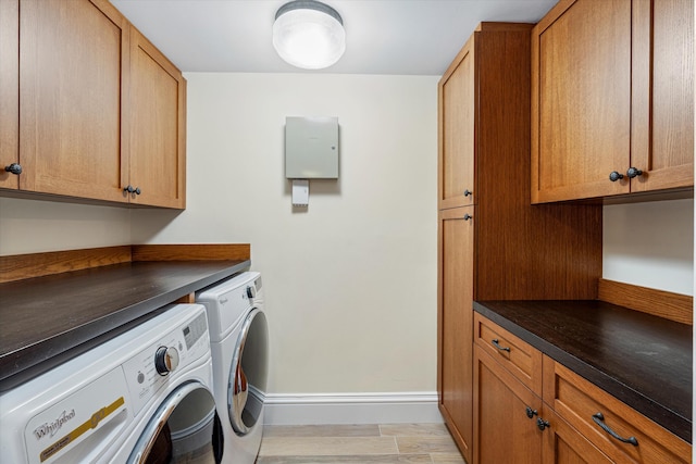 laundry area with washer and clothes dryer, cabinets, and light hardwood / wood-style floors