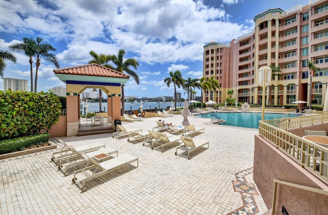 view of pool featuring a water view and a patio area