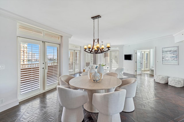 dining room featuring dark parquet flooring, crown molding, and an inviting chandelier