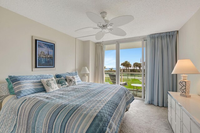 bedroom with floor to ceiling windows, ceiling fan, access to exterior, a textured ceiling, and light colored carpet