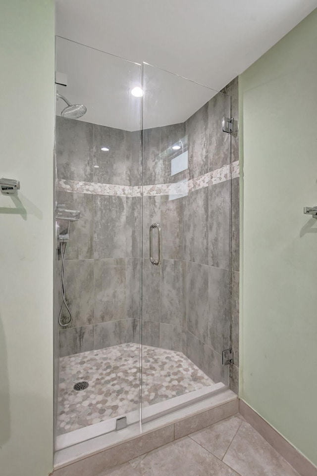 bathroom with tile patterned flooring and a shower with door