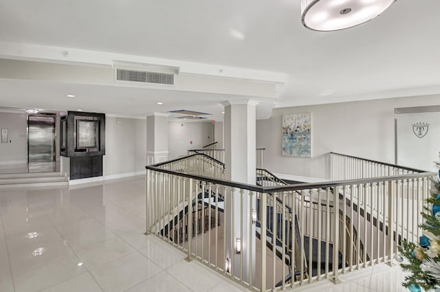 corridor featuring crown molding and light tile patterned floors