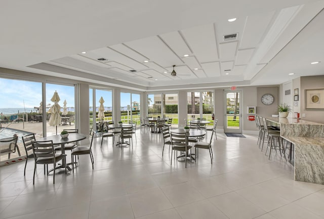 dining room with a raised ceiling and light tile patterned flooring