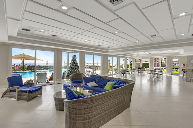 living room with a healthy amount of sunlight, a raised ceiling, and light tile patterned floors