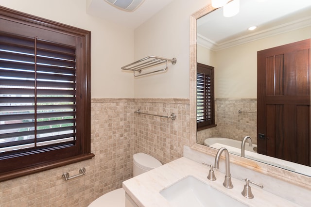 bathroom featuring ornamental molding, tile walls, vanity, and toilet