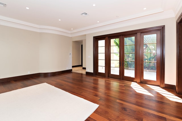 empty room featuring french doors, ornamental molding, and dark hardwood / wood-style floors