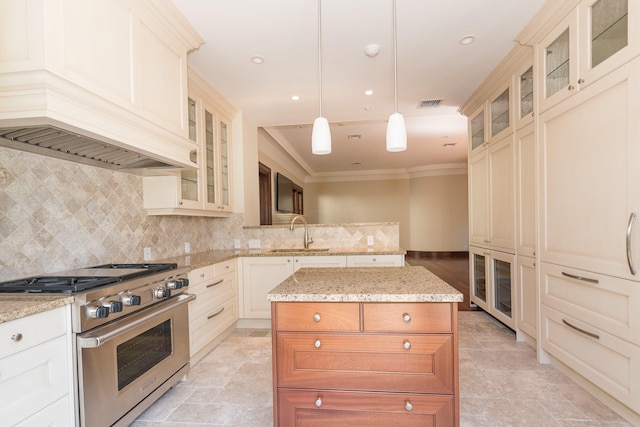 kitchen featuring sink, pendant lighting, a kitchen island, high end stainless steel range oven, and backsplash