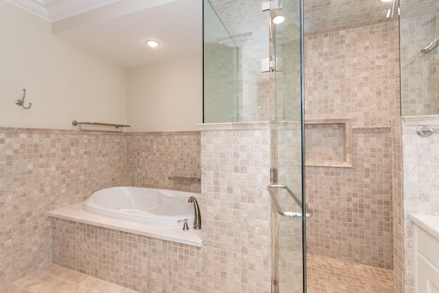 bathroom with plus walk in shower, ornamental molding, tile walls, and tile patterned floors