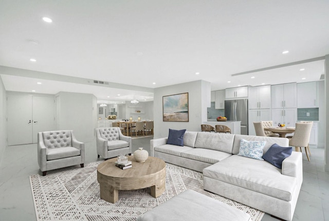 living area featuring recessed lighting, marble finish floor, and visible vents