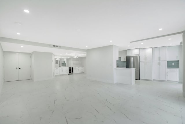 unfurnished living room with marble finish floor, wine cooler, visible vents, and recessed lighting