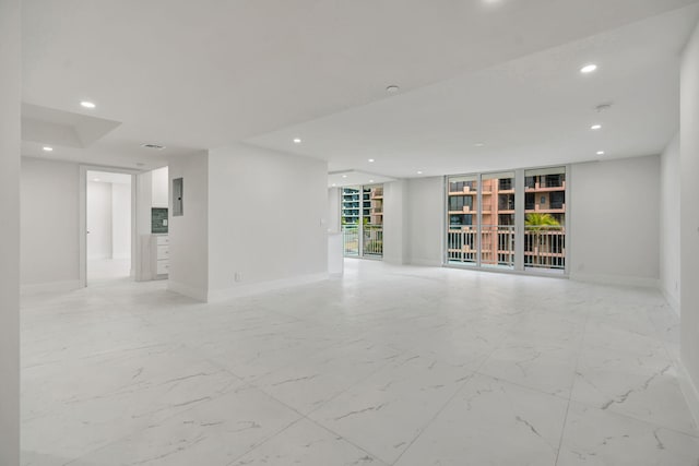 unfurnished living room featuring a wall of windows and electric panel