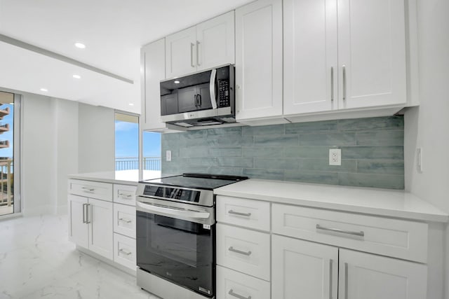 kitchen with tasteful backsplash, white cabinets, marble finish floor, stainless steel appliances, and recessed lighting