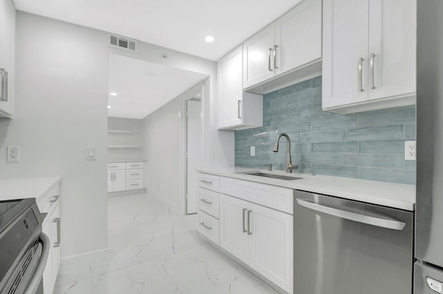 kitchen with stainless steel appliances, a sink, visible vents, white cabinetry, and marble finish floor