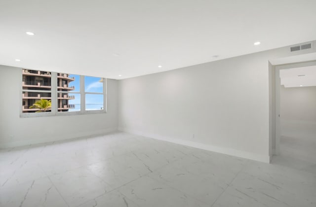 unfurnished room with recessed lighting, marble finish floor, visible vents, and baseboards