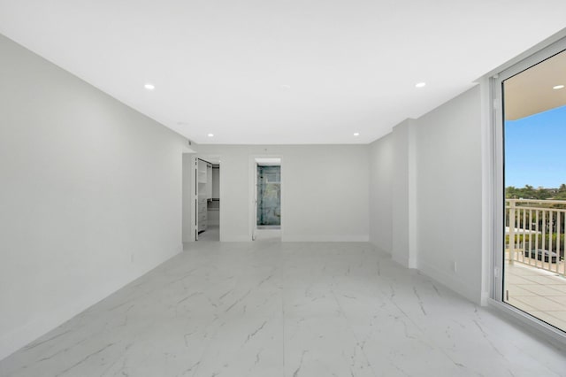 unfurnished room with a wall of windows, recessed lighting, marble finish floor, and baseboards