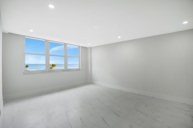 unfurnished room featuring recessed lighting, marble finish floor, and baseboards