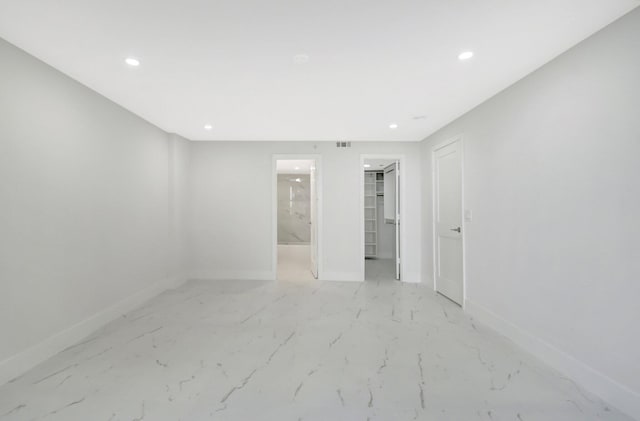 spare room featuring marble finish floor, baseboards, and recessed lighting