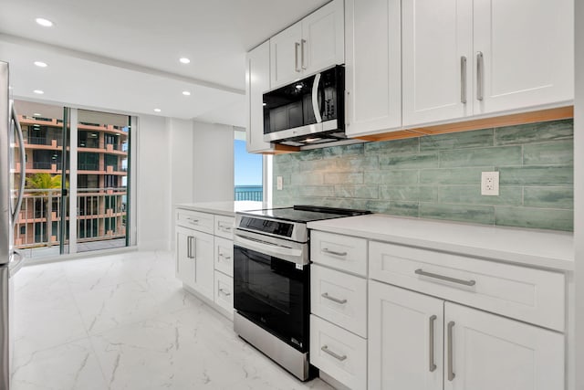 kitchen featuring stainless steel range with electric stovetop, decorative backsplash, and white cabinets