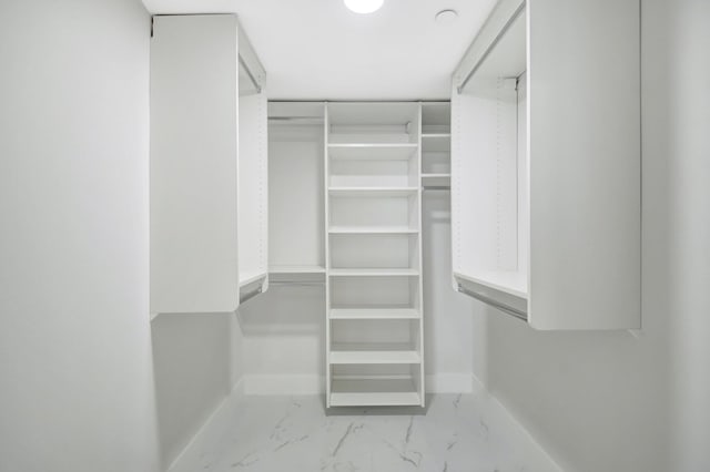 walk in closet with marble finish floor