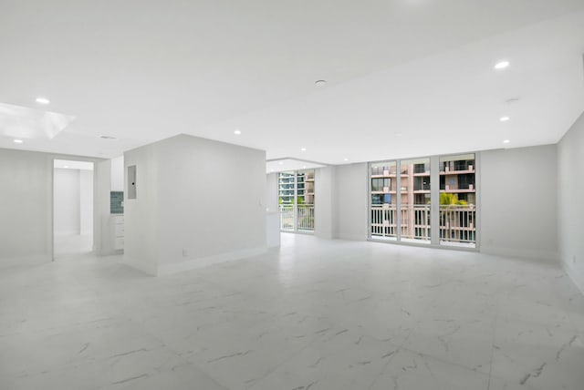 empty room with marble finish floor, electric panel, baseboards, and recessed lighting