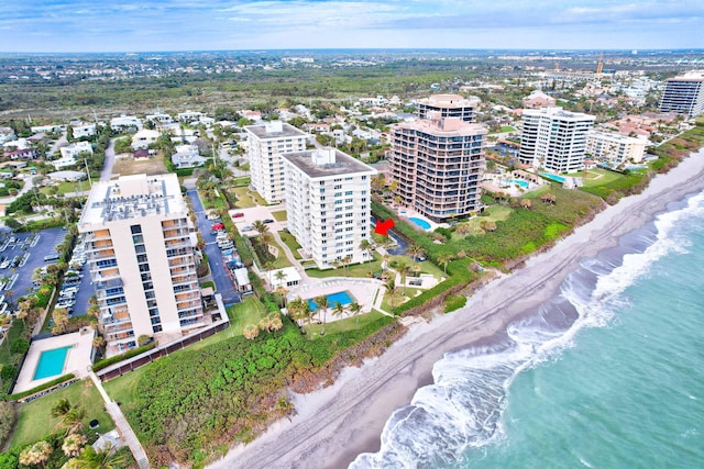 bird's eye view featuring a water view, a view of the beach, and a city view