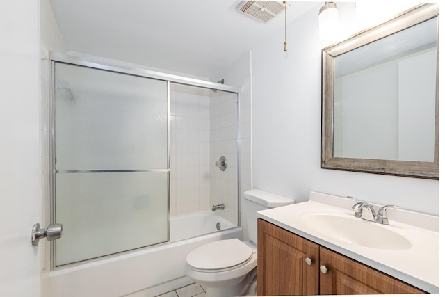 full bathroom featuring tile patterned floors, vanity, toilet, and bath / shower combo with glass door