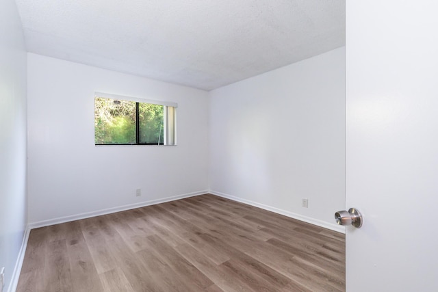 spare room with hardwood / wood-style floors and a textured ceiling