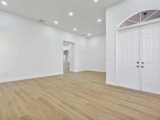 kitchen with light wood-type flooring, backsplash, stainless steel appliances, sink, and white cabinets