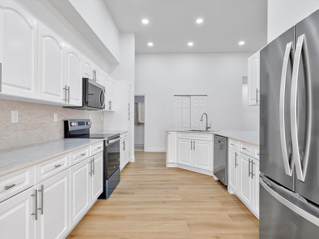 unfurnished living room featuring sink and light hardwood / wood-style flooring