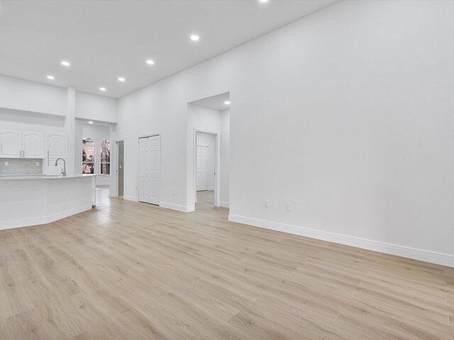 empty room with ceiling fan and light hardwood / wood-style flooring