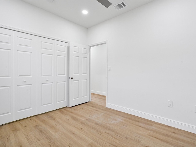 unfurnished bedroom featuring light wood-type flooring and a closet