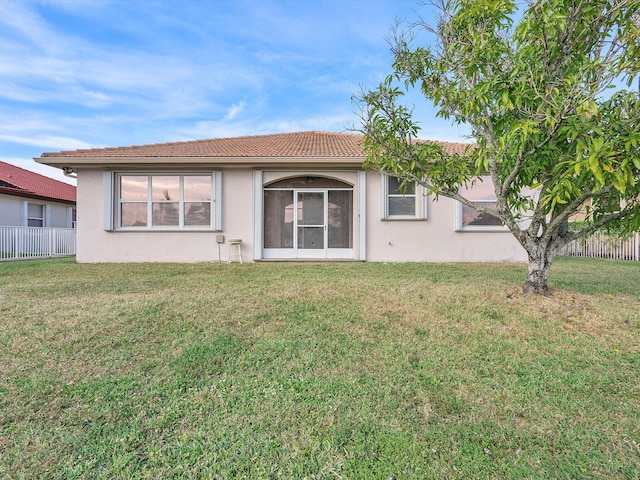 rear view of property featuring a lawn