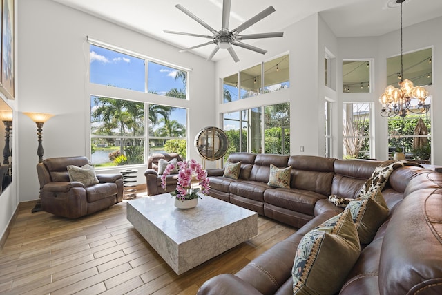 living room featuring a high ceiling and ceiling fan with notable chandelier